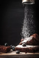 Foto op Plexiglas anti-reflex Sprinkling chocolate brownie with icing sugar vertical © deniskarpenkov