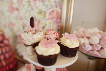 Delicious cupcakes on stand at candy bar