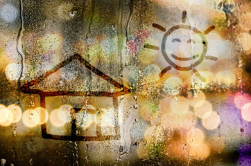 natural water drops on glass window with word house and the sun