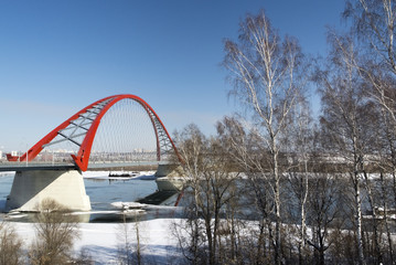 Red bridge across a river at winter time