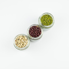 Obraz na płótnie Canvas Black eye peas, mung bean and adzuki beans in a mason jar over white background