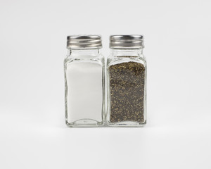 Glass salt and pepper shakers on white background