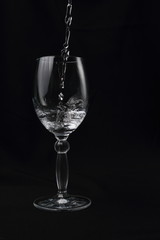 crystal cup with falling water on black background
