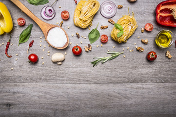 Healthy foods, cooking and vegetarian concept pasta with flour, vegetables, oil and herbs on wooden rustic background top view border, place for text