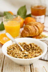 Breakfast table with granola, juice and croissant