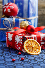 Christmas gift boxes and orange slice on table.