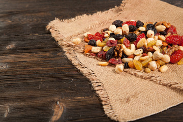 Dried fruits. Hazelnuts, almonds, cashews, apricots, cherries, walnuts, raisins. Background - burlap. Vintage.