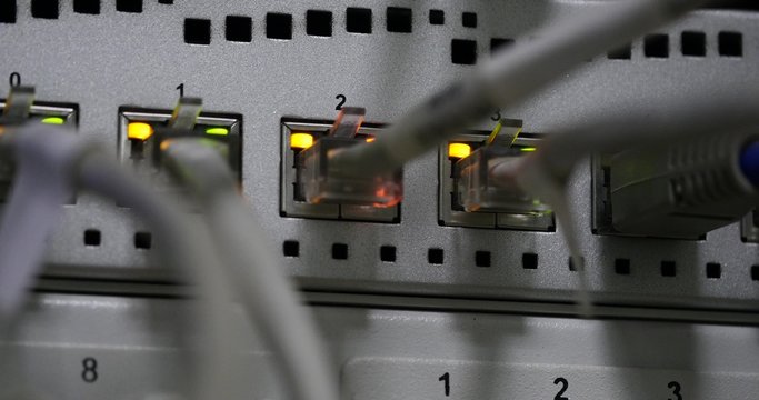 Details of UTP cables, blinking LED lights and RJ 45 on working Ethernet switches