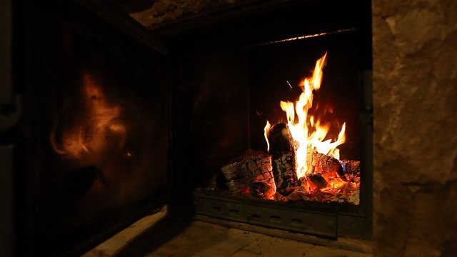 Wood logs fire burn in fireplace, romantic atmosphere