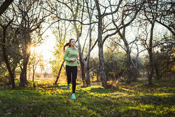 Obraz premium young sporty caucasian female running in autumn park