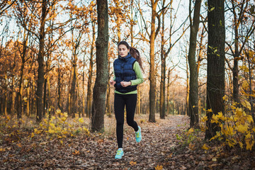 Fototapeta premium young sporty caucasian female running in autumn park
