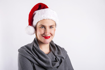 Woman in christmas hat smiling over white background.