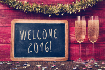 confetti, champagne and text welcome 2016