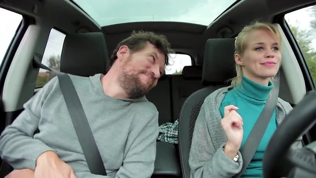 Blond Woman With Man Dancing In Car A Little While Driving