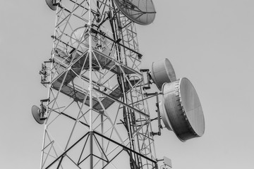 Telecommunications tower on sky background in black and white co