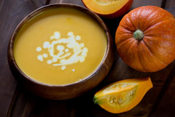 Close-up of pumpkin soup with cream topping, selective focus