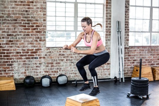  Fit woman doing jumping squats