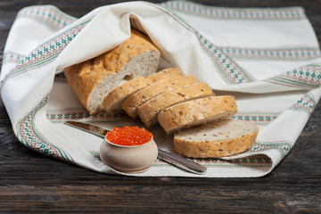 Bread and red caviar on a wooden background.