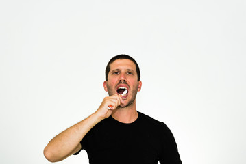 close-up of young caucasian man brushing his teeth -  isolated on white background with copyspace