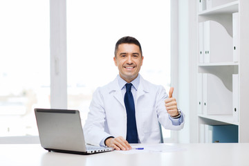 smiling doctor showing thumbs up in medical office