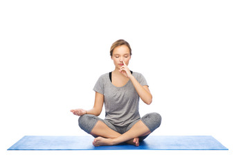 woman making yoga meditation in lotus pose on mat