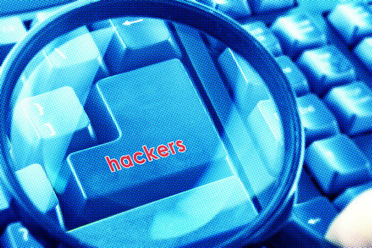 Magnifying glass on keyboard with Hackers word on button. Color halftone effect applied.