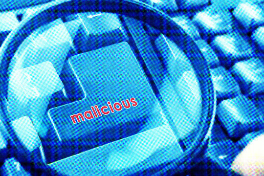 Magnifying glass on keyboard with Malicious word on button. Color halftone effect applied.