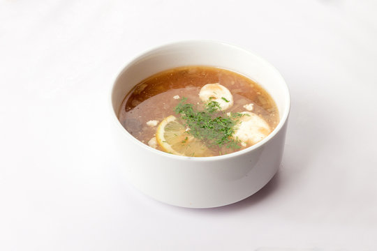 суп солянка на белом фоне в тарелке