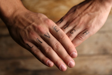Tattoo inscriptions on male fingers drawn with marker