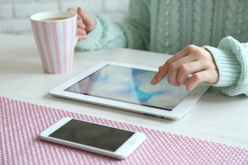 Woman using digital tablet on table close-up