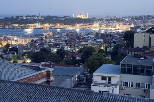 A good view over the rooftops of the high rising building in istanbul with the Bosphorus seen behind a hill and the mosque of Sultan Ahmet in the distance