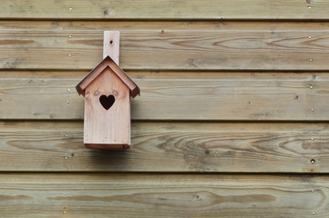 Obraz na płótnie Canvas Home is where your heart is. bird home with wooden background