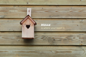 Obraz na płótnie Canvas Home is where your heart is. bird home with wooden background