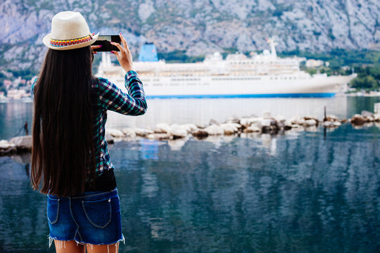 girl taking photo of cruise liner
