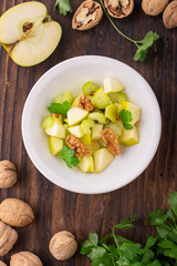 Light fresh spring salad with green apple, stem celery, walnuts