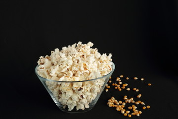 Popcorn in a glass bowl on black background
