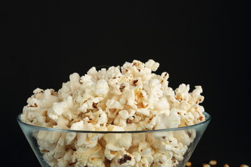 Popcorn in a glass bowl on black background
