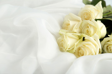 Bouquet of white roses on white fatin