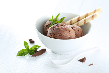 Sweet chocolate ice cream in bowl on grey wooden background