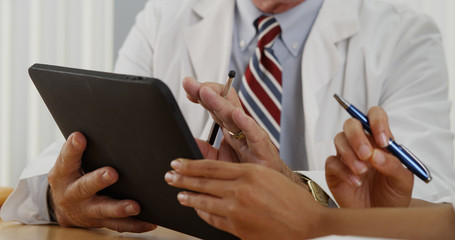 Closeup of two doctors using a tablet in the office