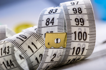 Curved measuring tape. Measuring tape of the tailor. Closeup view of white measuring tape