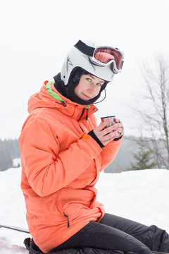 Girl with a snowboard and tea