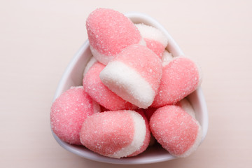 Pink jellies or marshmallows with sugar in bowl
