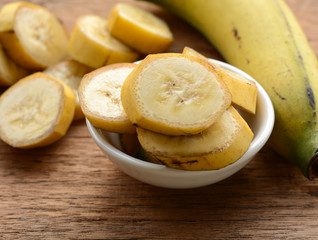 sliced banana in a cup over a table.