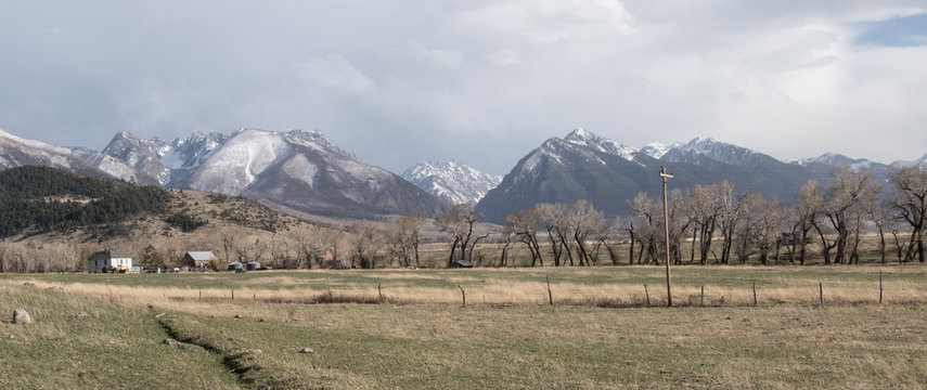 a montana ranch in the paradise valley in the rocky mountains, a barbed wire fence, old homestead, and farm buildings