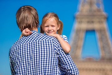 Fototapeta na wymiar Happy father and little adorable girl in Paris near Eiffel Tower during summer french vacation