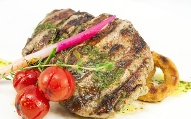 Grilled steak with sauce and greens on white background