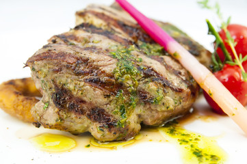 Grilled steak with sauce and greens on white background