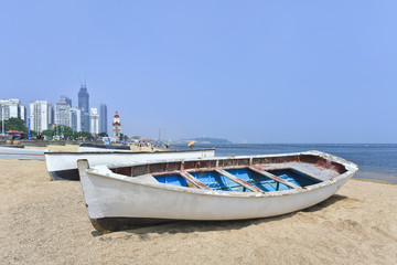 White wooden row boat on a sunny beach.