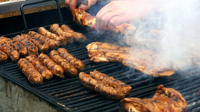 Romanian sausages (mici), skewers, and pork prepared on the grill. 4K footage.